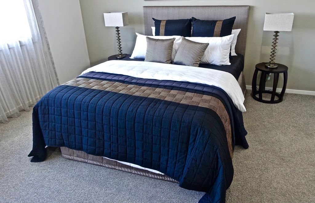 A guest room with a large bed and soft lighting